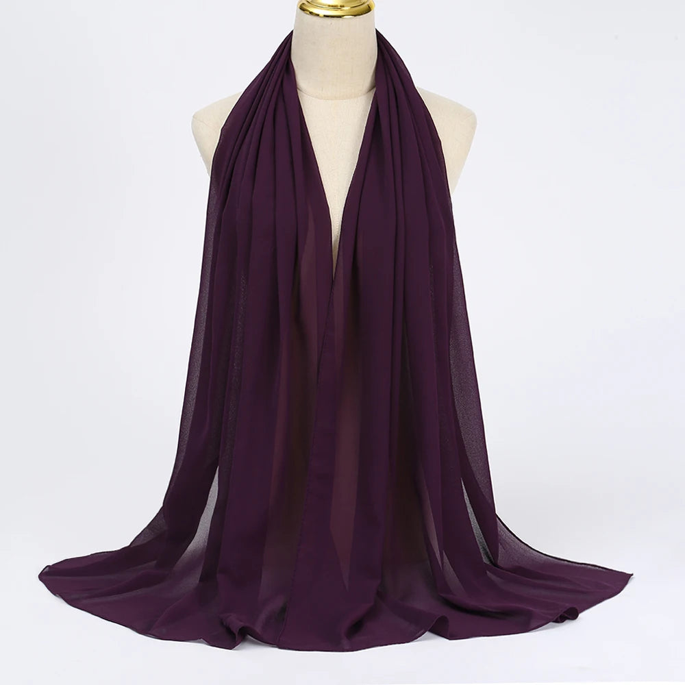 Ein tiefviolettes Chiffon-Hijab-Tuch, um den Hals einer Mannequin gewickelt.