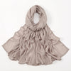 Ein weicher beige Viskose-Hijab elegant um den Hals und die Schultern drapiert.