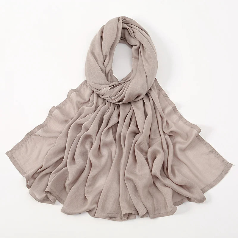 Ein weicher beige Viskose-Hijab elegant um den Hals und die Schultern drapiert.