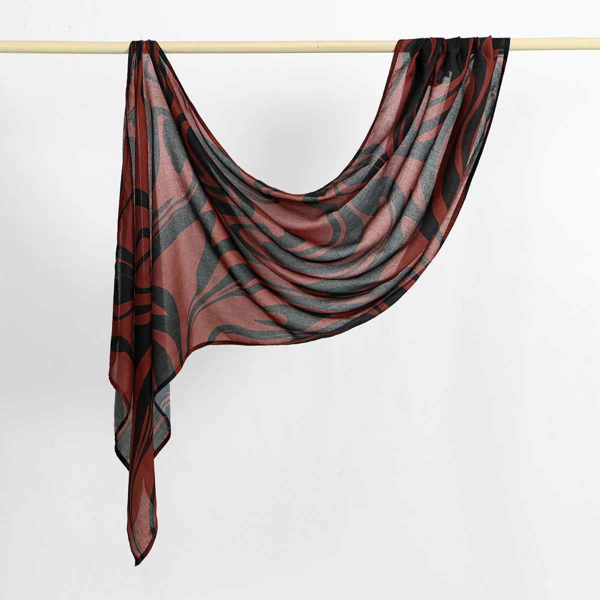 Dunkelbraun und schwarzes Aquarell-Stoff-Linen-Hijab-Schal über einem Haken drapiert.
