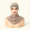 Una modelo lleva una elegante capucha de hijab beige con bordado plateado y un pañuelo de tela a juego.