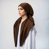 A woman wearing a brown satin silk instant hijab scarf over a white garment.