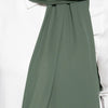 A close-up of a sage green chiffon scarf draped around the neck, paired with a white top.