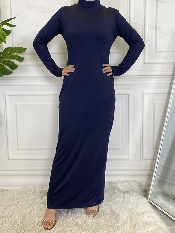 A navy blue elegant turtle neck maxi abaya dress displayed on a mannequin against a white paneled wall.