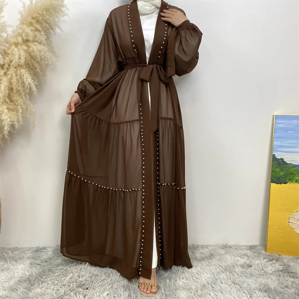 Cardigan abaya marrón elegante con mangas largas y detalles de cuentas, exhibido contra una pared blanca.