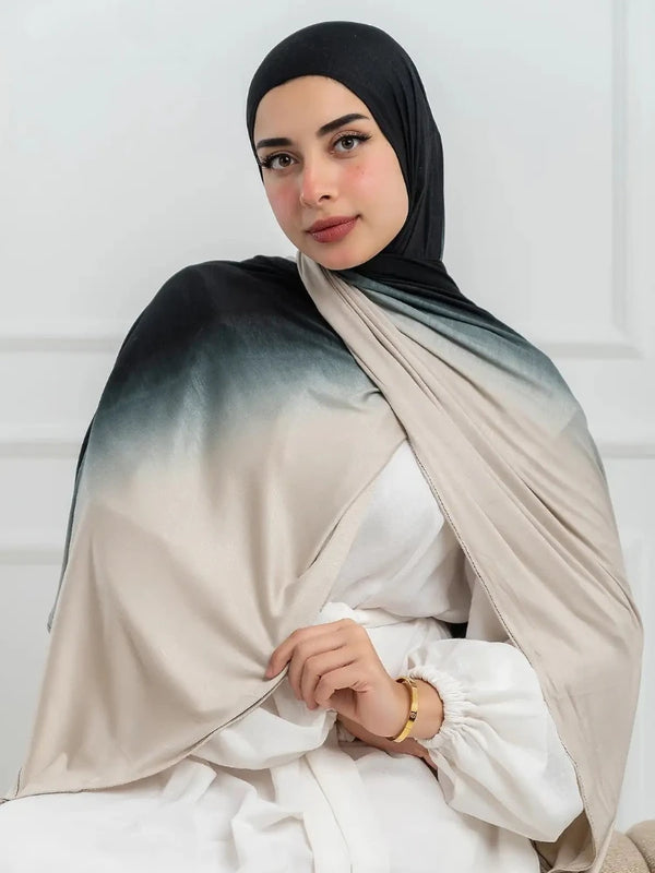 A woman wearing a double-sided gradient cotton hijab scarf in beige and gray tones.