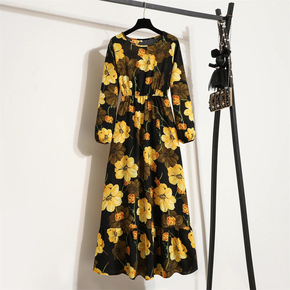 Schwarzes Maxi-Kleid mit leuchtend gelbem und braunem Blumenmuster an einem Kleiderständer.