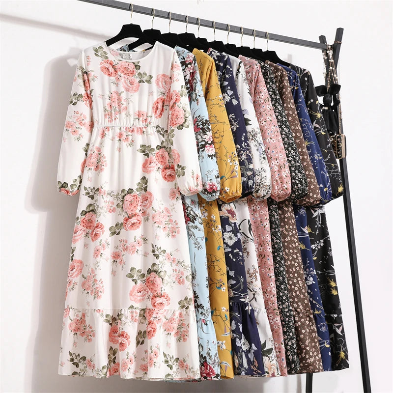 Ein Regal mit verschiedenen Boho-Kleidern mit floralen Mustern in Pastell- und dunklen Farben.