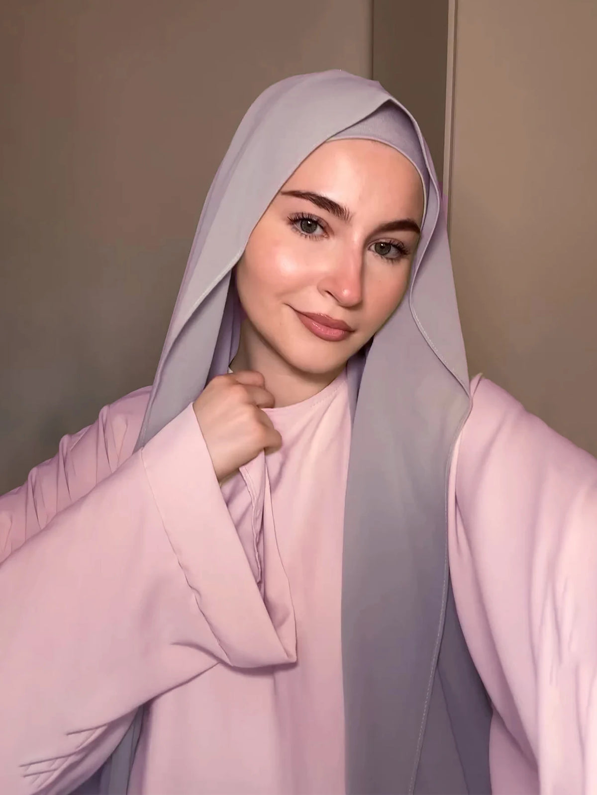 A woman wearing a lilac chiffon matching inner scarf set, featuring a pink top and a lilac hijab.