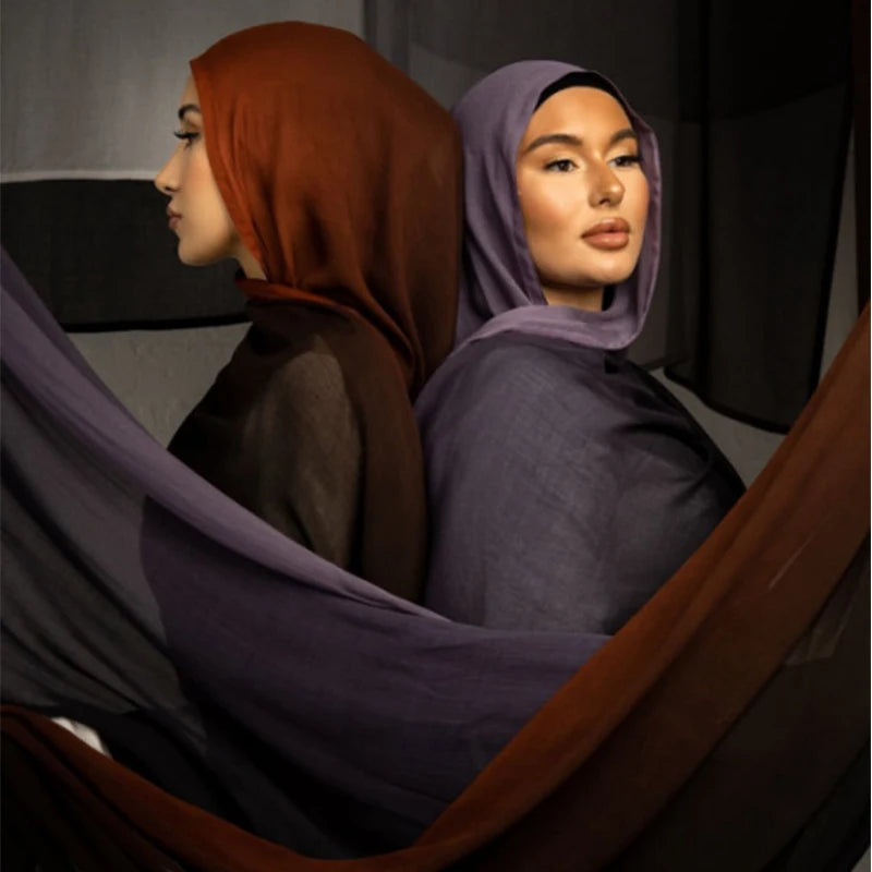 Eine Frau mit lila und orange-brauner Hijab schaut zur Seite.