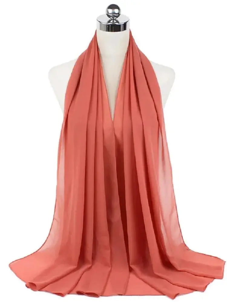 Fließender Korallen-Chiffon-Hijabschal, um den Hals eines Mannequins drapiert.