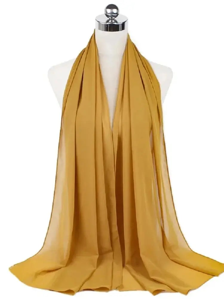 Fließender, durchgehender senffarbener Chiffon-Hijab-Schal über einem Mannequin