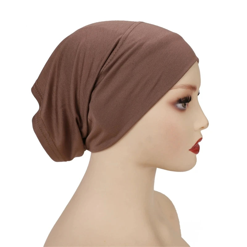 Primer plano de un gorro hijab de modal suave y elástico marrón, usado en un maniquí.