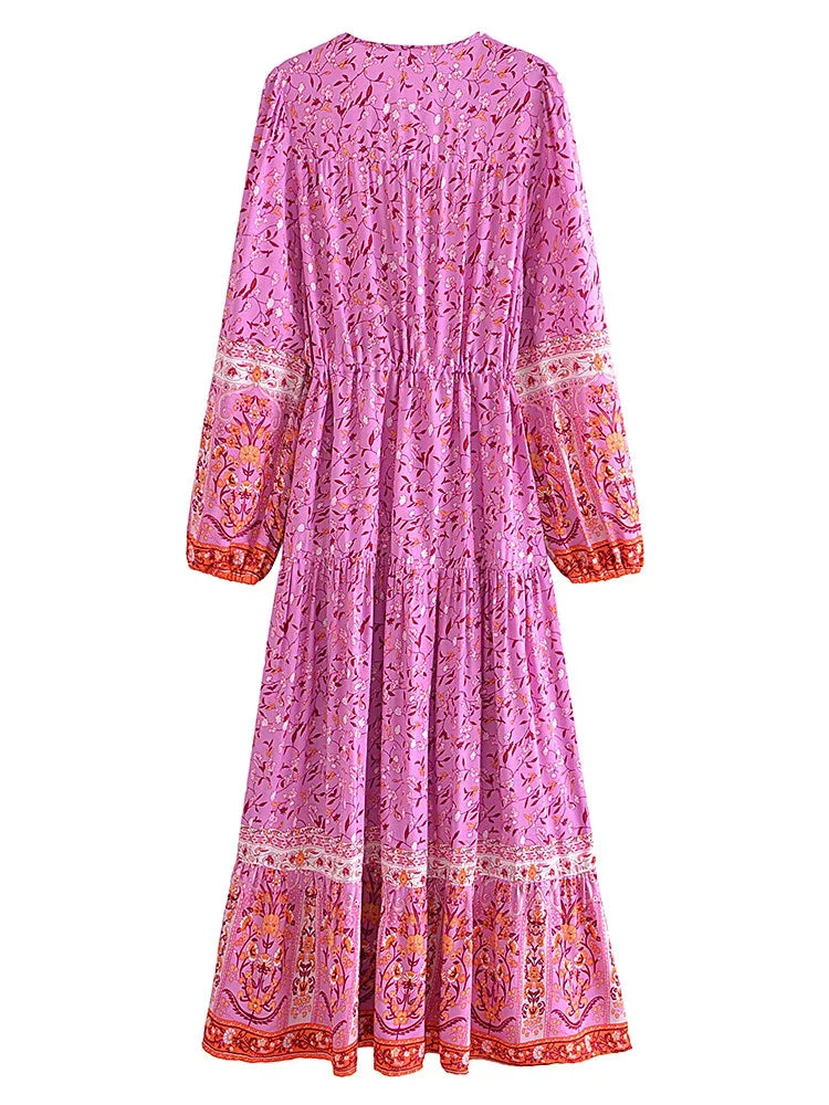 A long-sleeved pink maxi dress with floral embroidery and lantern sleeves.