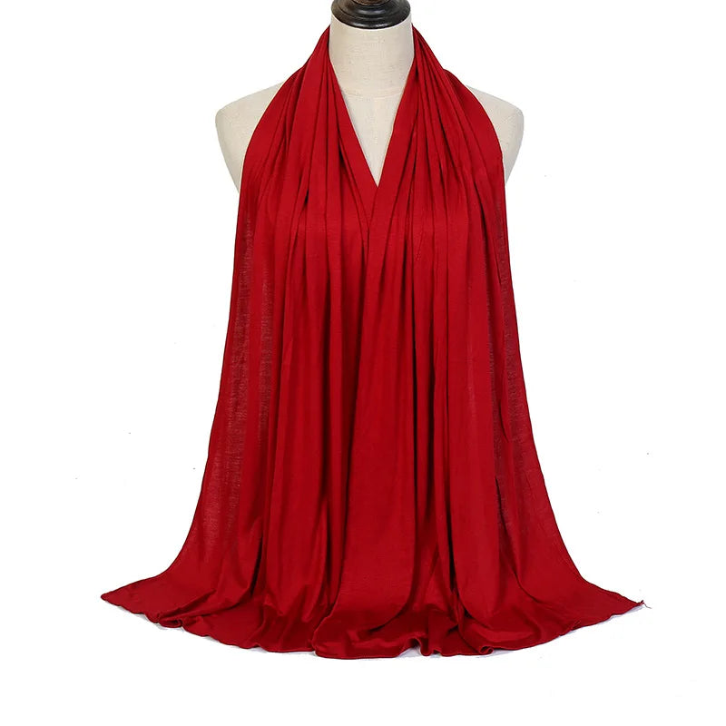Pañuelo hijab de algodón modal rojo vibrante premium drapeado alrededor del cuello de un maniquí.
