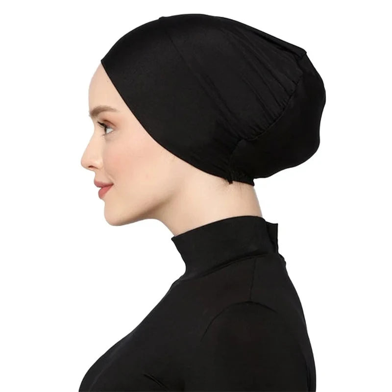 Una mujer vistiendo un turbante instantáneo negro y ropa negra.