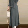 Une femme portant une élégante robe maxi gris à plis à manches longues et un hijab assorti.