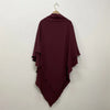 A deep burgundy two-layer everyday hijab scarf draped on a hanger against a white wall.