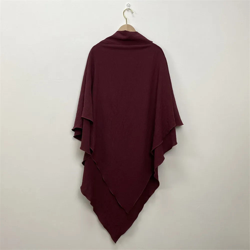A deep burgundy two-layer everyday hijab scarf draped on a hanger against a white wall.