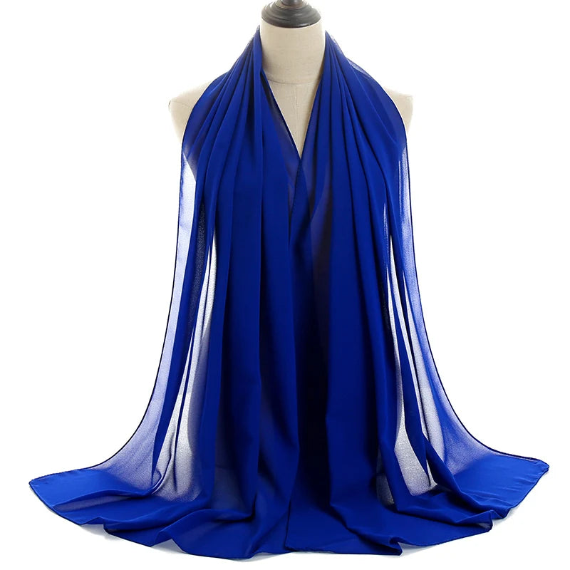 Un vibrante pañuelo de chifón azul real drapeado alrededor del cuello de un maniquí.