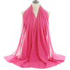 Un pañuelo de chifón rosa brillante drapeado alrededor del cuello de un maniquí.