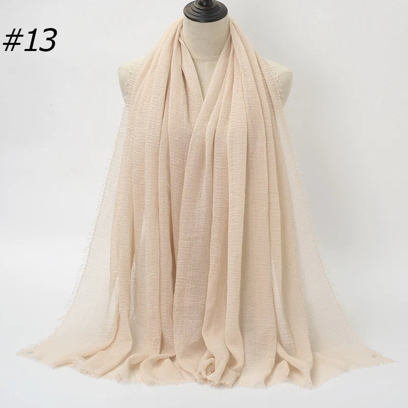Beige gekräuseltes Baumwoll-Hijab-Schal um den Hals eines Mannequins drapiert.