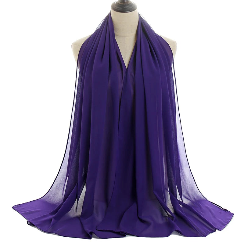 Un pañuelo de chifón morado drapeado alrededor del cuello y los hombros de un maniquí.