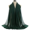 Un pañuelo de chifón verde esmeralda oscuro drapeado alrededor del cuello de un maniquí.