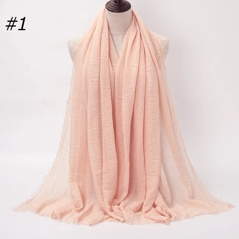 Helles Pfirsich-Crinkle-Baumwoll-Hijab-Schal, um den Hals eines Mannequins gewickelt.
