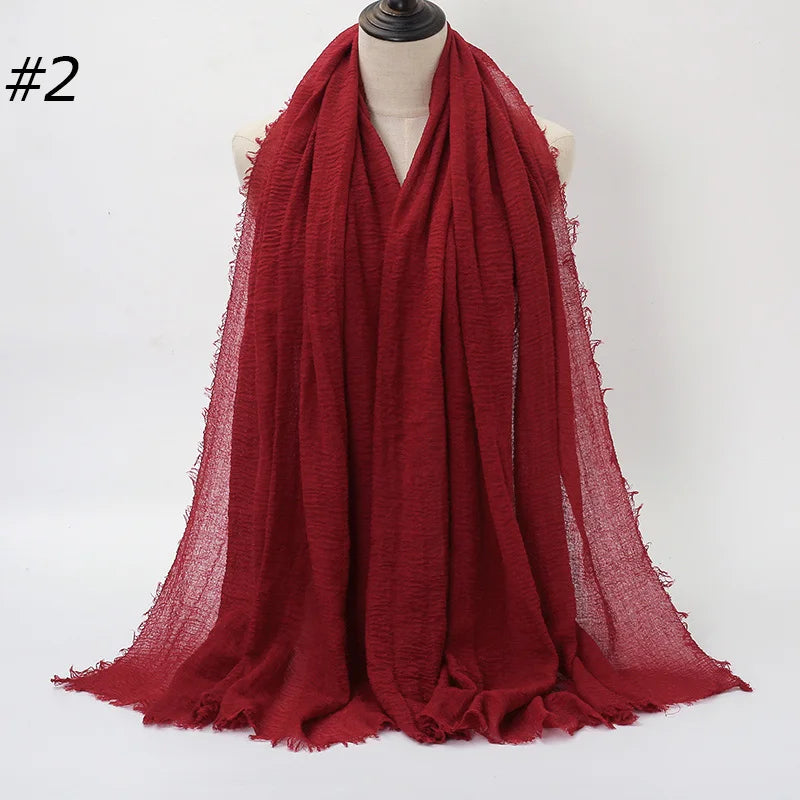Tiefrote crinkelige Baumwoll-Hijab-Schal über einem Mannequin drapiert.