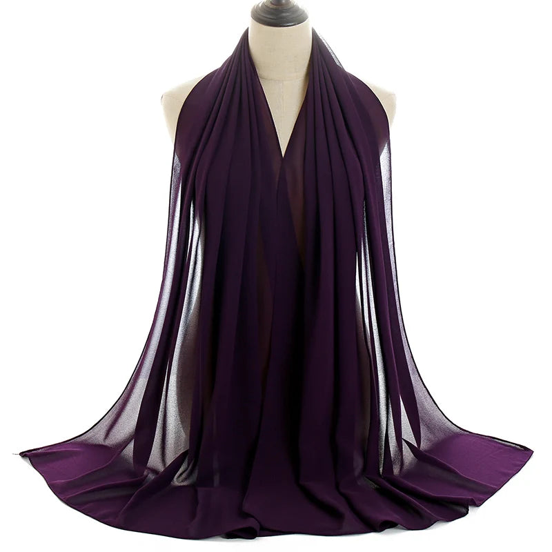 Un pañuelo de chifón morado intenso drapeado alrededor del cuello de un maniquí.