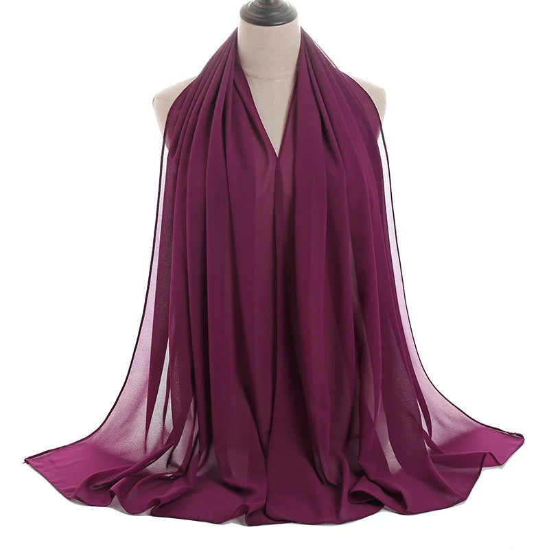 Un pañuelo de chifón magenta intenso drapeado alrededor del cuello y los hombros de un maniquí.