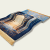 Un élégant tapis de prière musulman bleu et or avec des bordures rayées et des motifs complexes.